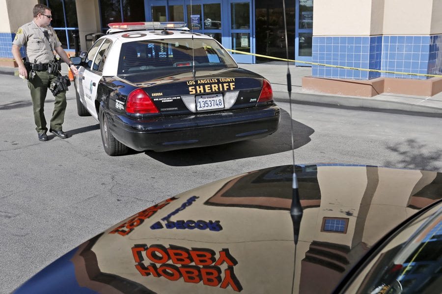 A deputy checks on a robbery suspect in the back of his patrol car after an attempted robbery at Hobby Lobby in Saugus on Monday. Katharine Lotze/Signal